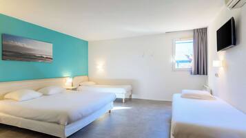 Ein Hotelzimmer mit zwei Betten, einem Fernseher und einem Bild an der Wand.
