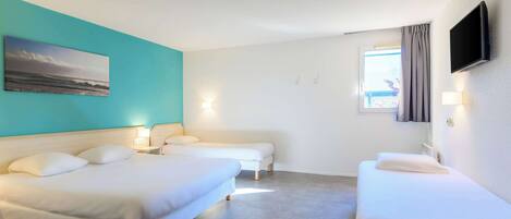 Habitación de hotel con dos camas, un televisor y un cuadro en la pared.