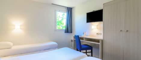 Une chambre d’hôtel comprenant un lit, un bureau, une chaise, une télévision et une armoire.