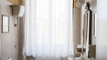 Une salle de bain comprenant des toilettes, un bidet, un lavabo et une baignoire.