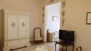 Een slaapkamer met een grote kledingkast, een televisie en een bed met handdoeken.