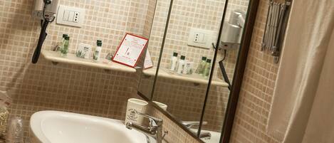 A bathroom with a sink, mirror, and toiletries.