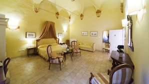 A hotel room with a bed, two chairs, a table, a sofa, and a desk. - Palazzo Guiderocchi (Ascoli Piceno)