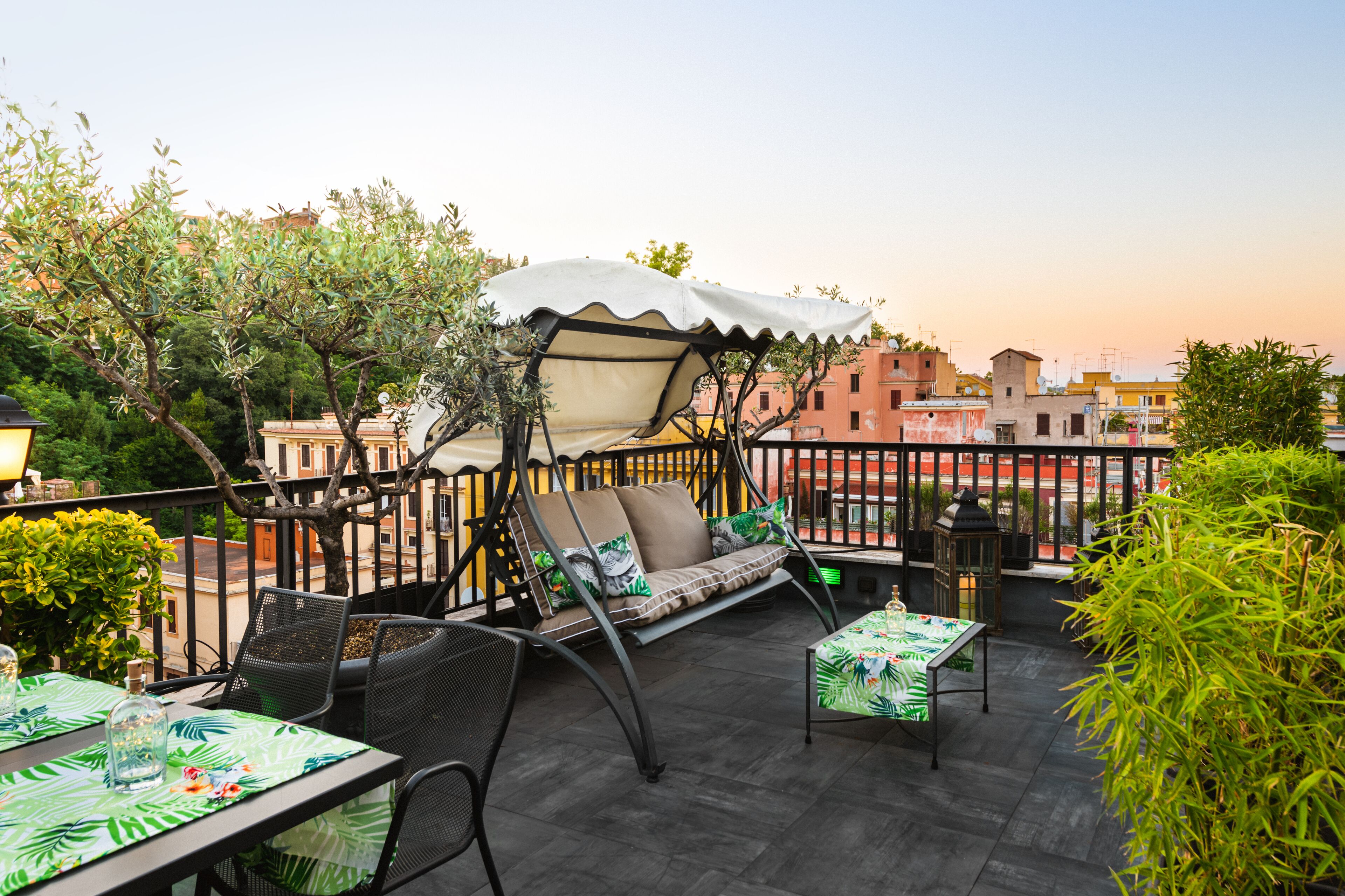 Terraza en la azotea con zona de estar, mesas y una pérgola.