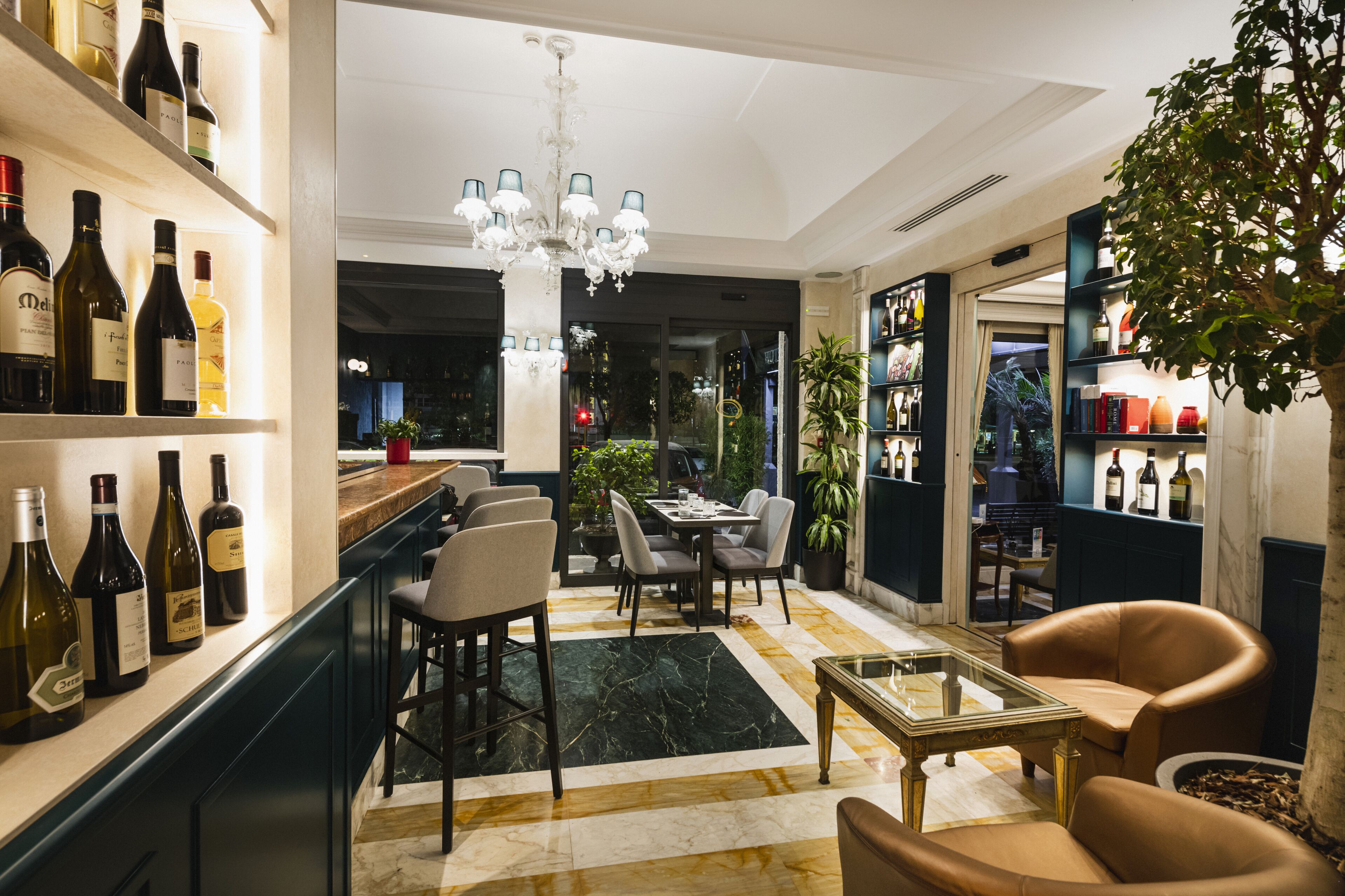 Een modern interieur met een bar, een eethoek en een zithoek met een kroonluchter.