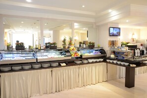 A buffet area with a variety of food items, including fruits and beverages, and a television mounted on the wall. - Trilussa Palace Wellness & Spa (Rome)