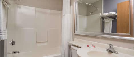 Un baño con bañera, inodoro, lavabo y espejo.