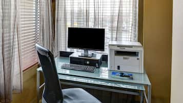 A modern office desk with a computer, keyboard, and printer.