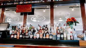 Zona de bar con varias botellas de licores y un letrero que dice "Tavern at the Inn".