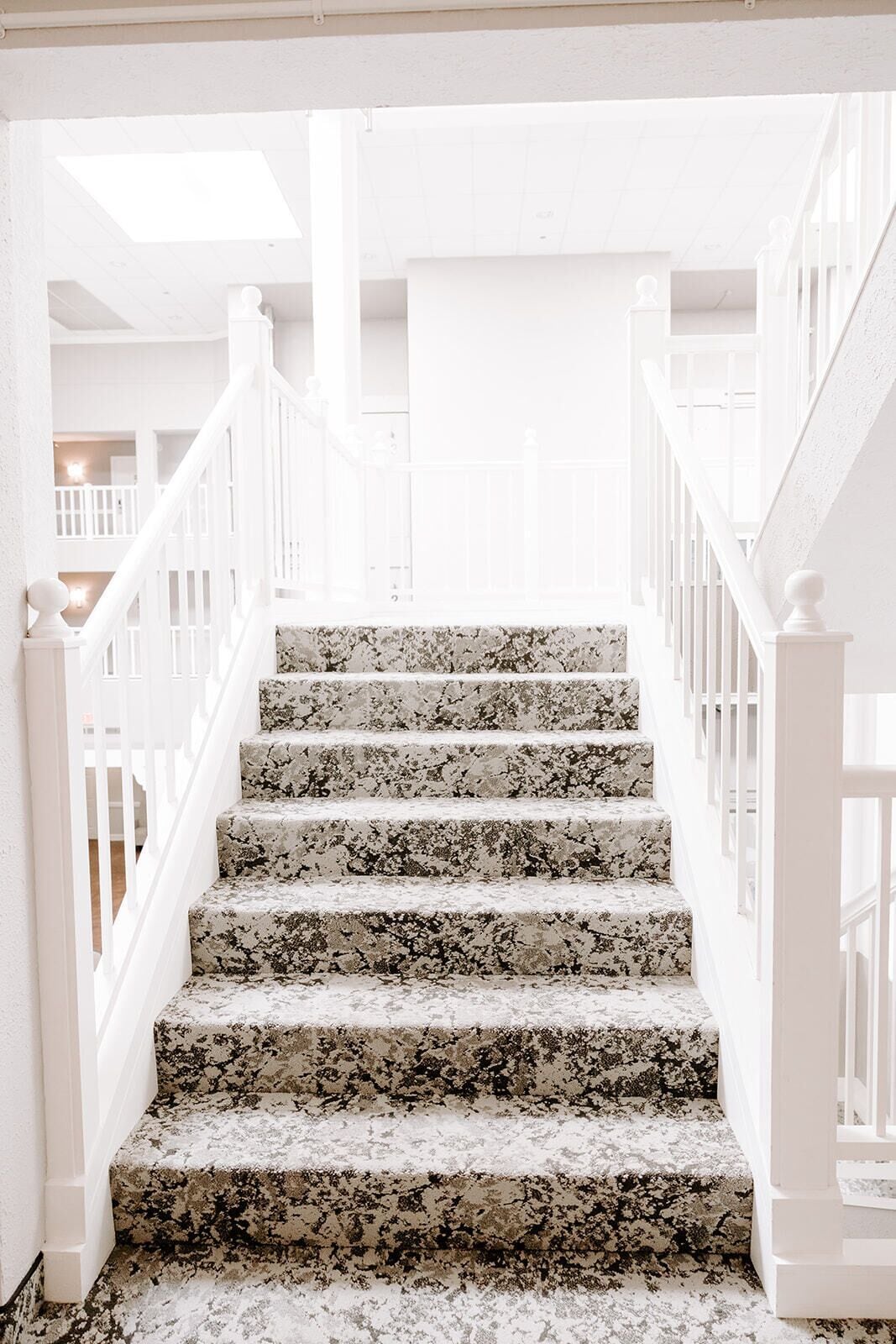 Un escalier avec des rampes blanches et un revêtement en terrazzo.