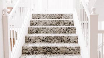 A staircase with white railings and a terrazzo finish.