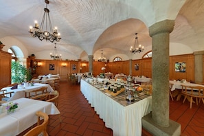 Enjoy a formal dining experience in this elegant space with vaulted ceilings, stone columns, and wooden paneling.