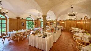 A spacious dining hall with high arched ceilings, wooden tables and chairs, and a central buffet area. - Hotel Lechnerhof (Unterfoehring)
