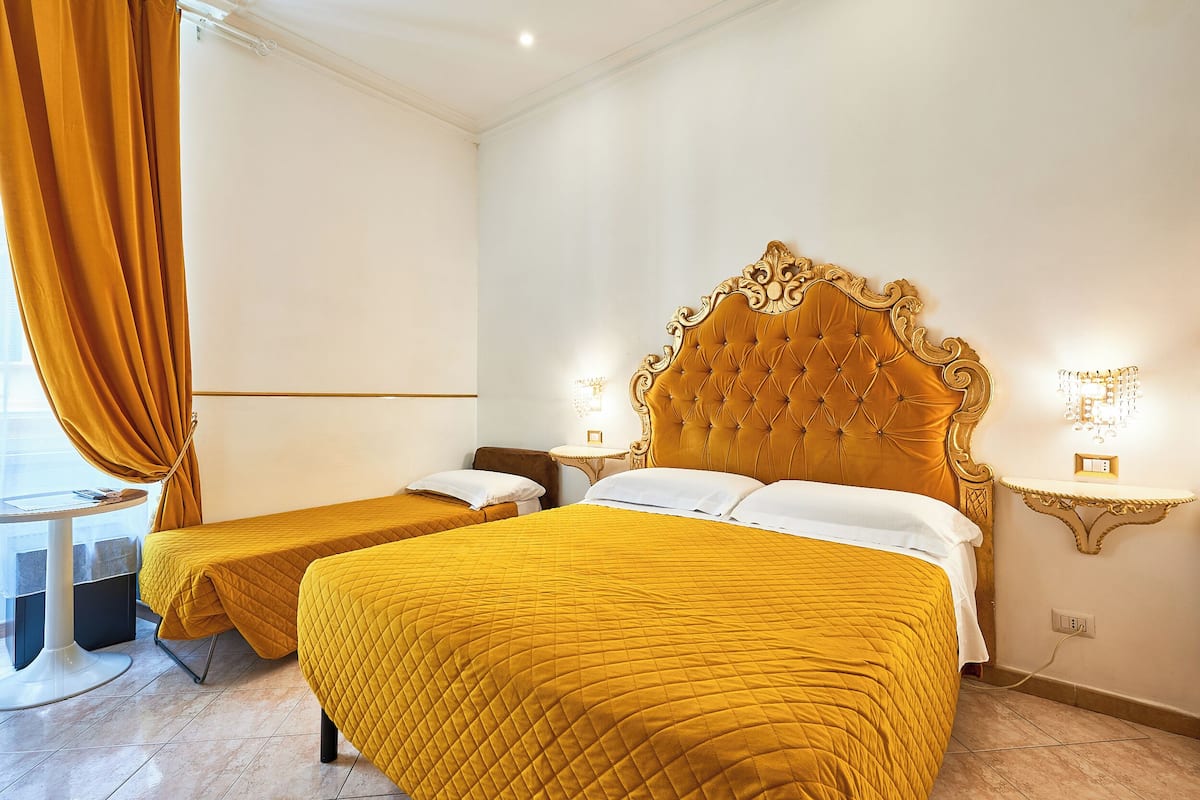 Une chambre d’hôtel avec deux lits, une petite table et une chaise.