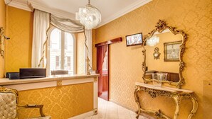 A luxurious room with a chandelier, a television, and ornate furniture. - Virginia Hotel (Rome)
