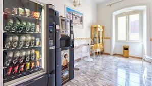 A hotel lobby with a vending machine, a chandelier, and a framed picture on the wall. - Virginia Hotel (Rome)