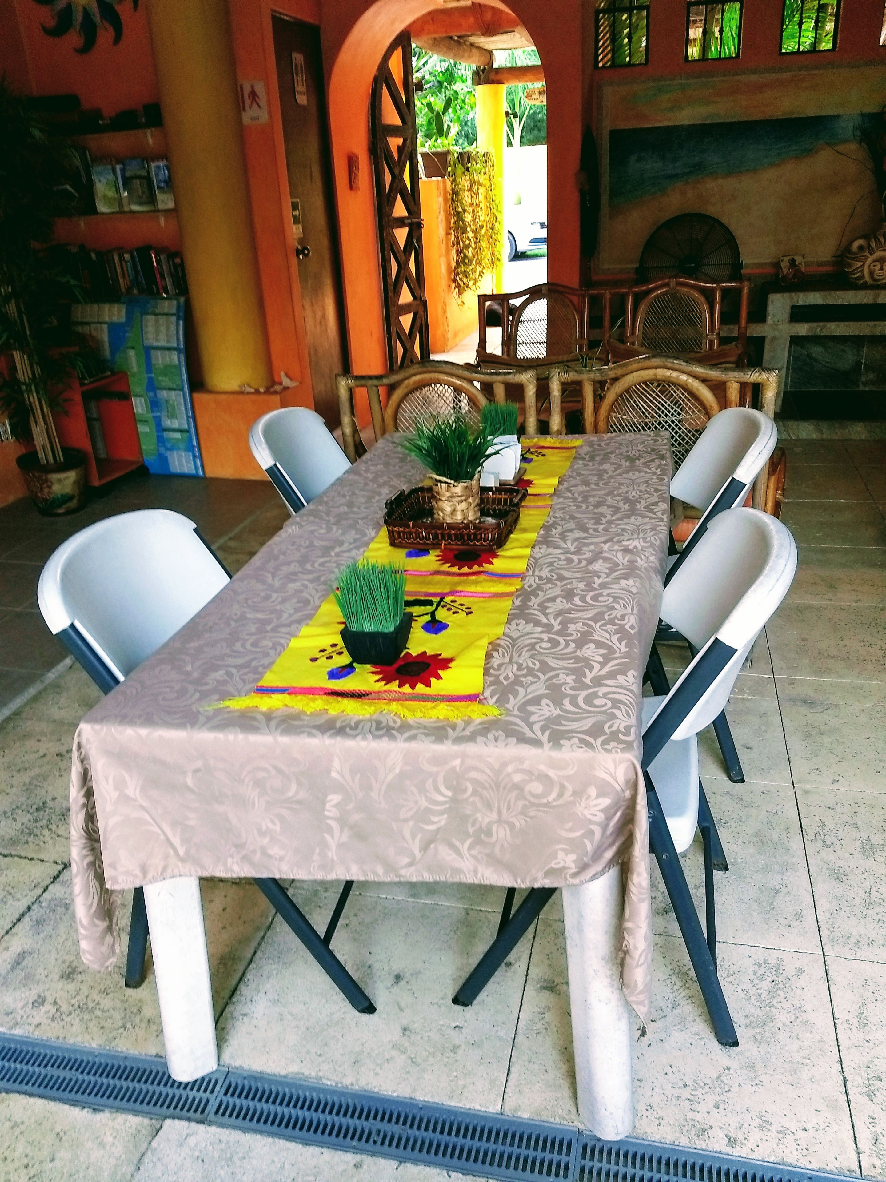 Ein Essbereich mit einem Tisch, gedeckt für sechs Personen, umgeben von weißen Stühlen.