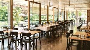 A spacious indoor dining area with high ceilings and large windows. Tables are set with chairs and dining ware. - TOP HOTEL ODELYA Basel (Basel)