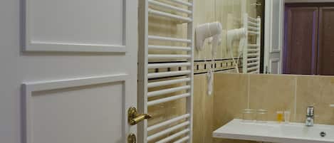 A bathroom with a white door, a towel rack, a sink, and a mirror.