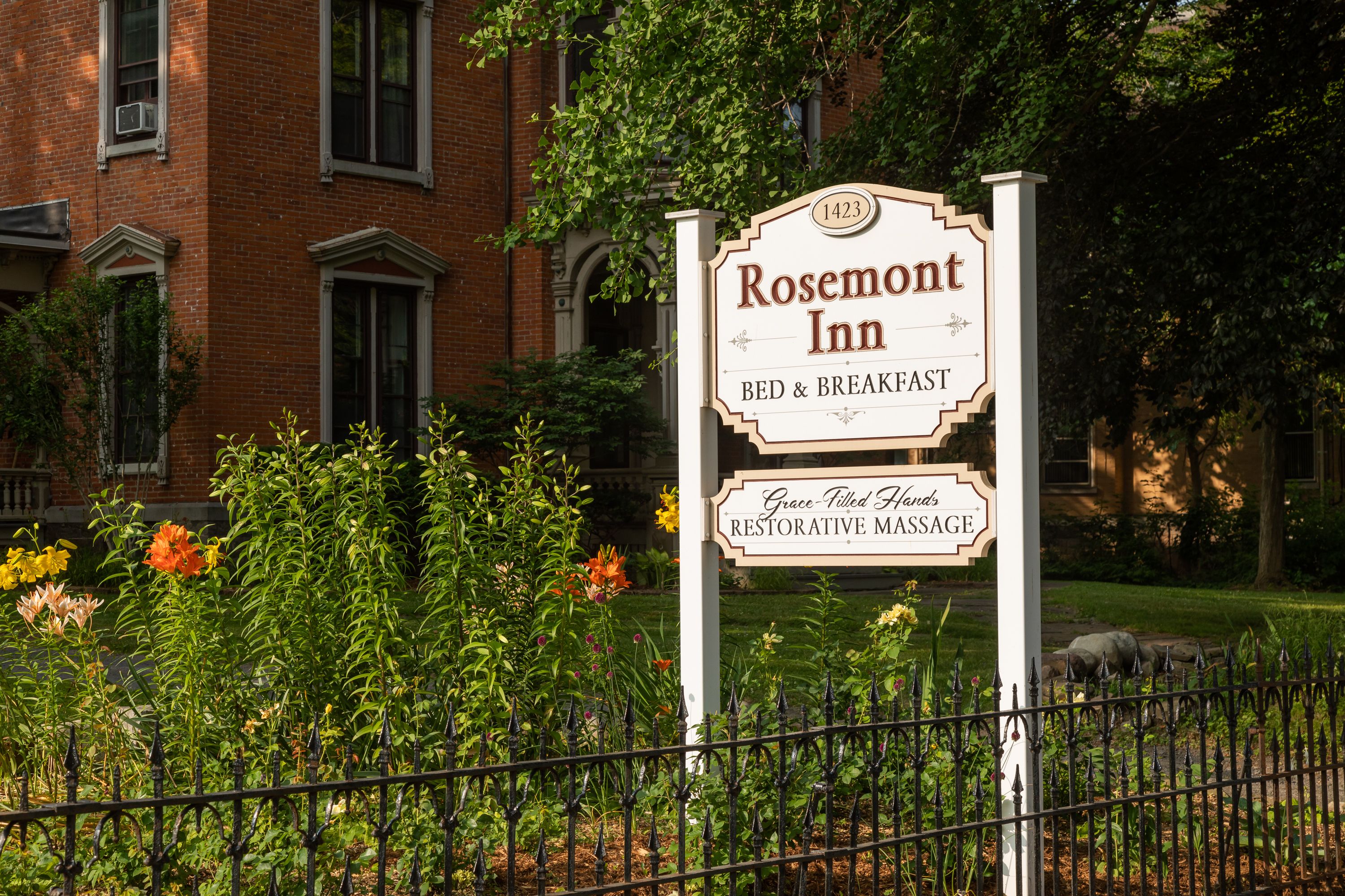 A sign for 'Rosemont Inn' with 'BED & BREAKFAST' and 'Grace-Tiled Fawns RESTORATIVE MASSAGE' services.