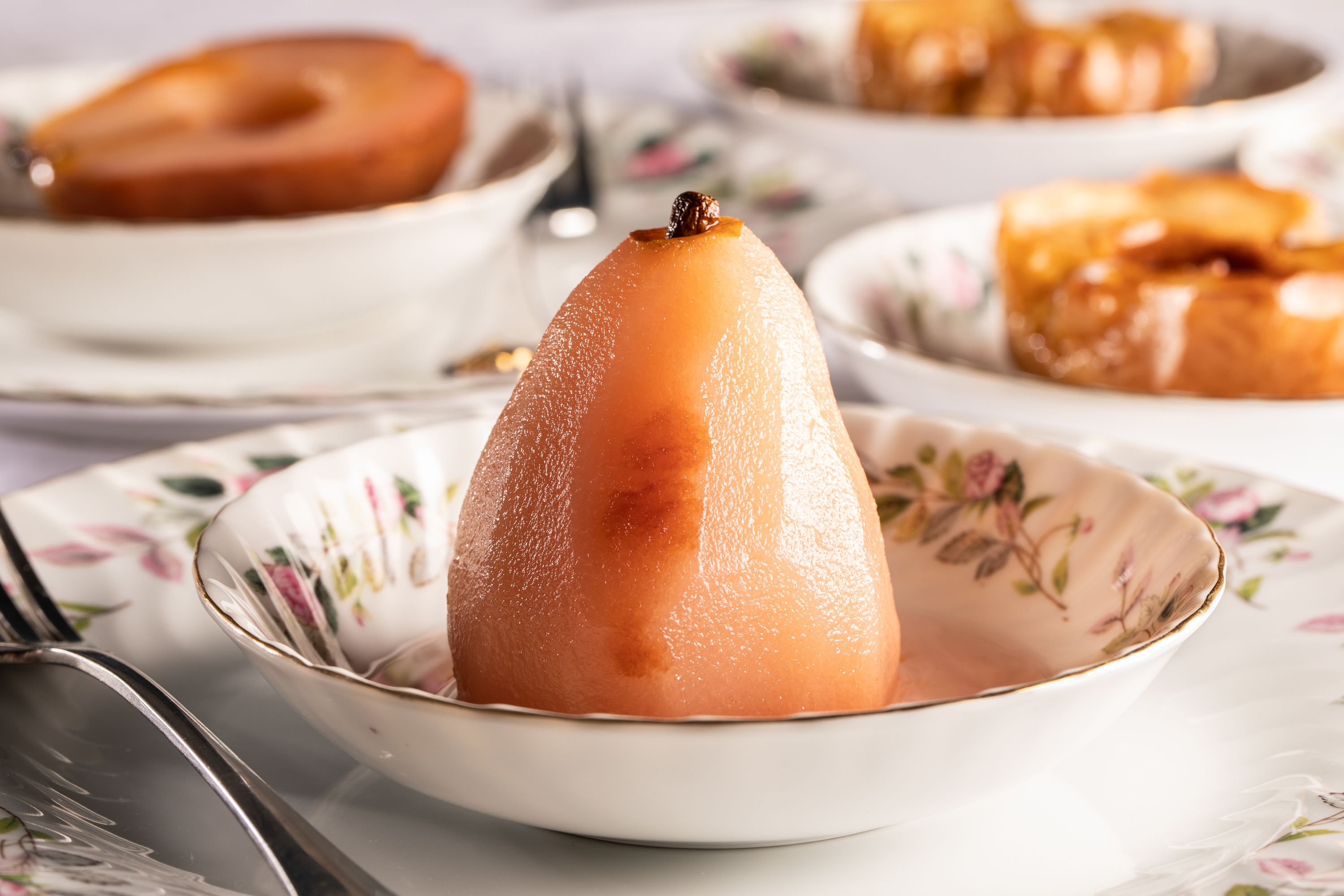Un postre con forma de pera en un cuenco con motivos florales.