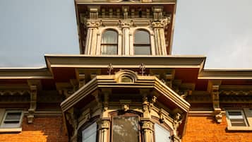 Esquina de un edificio con detalles arquitectónicos ornamentales, incluyendo un ventanal saliente y molduras decorativas.