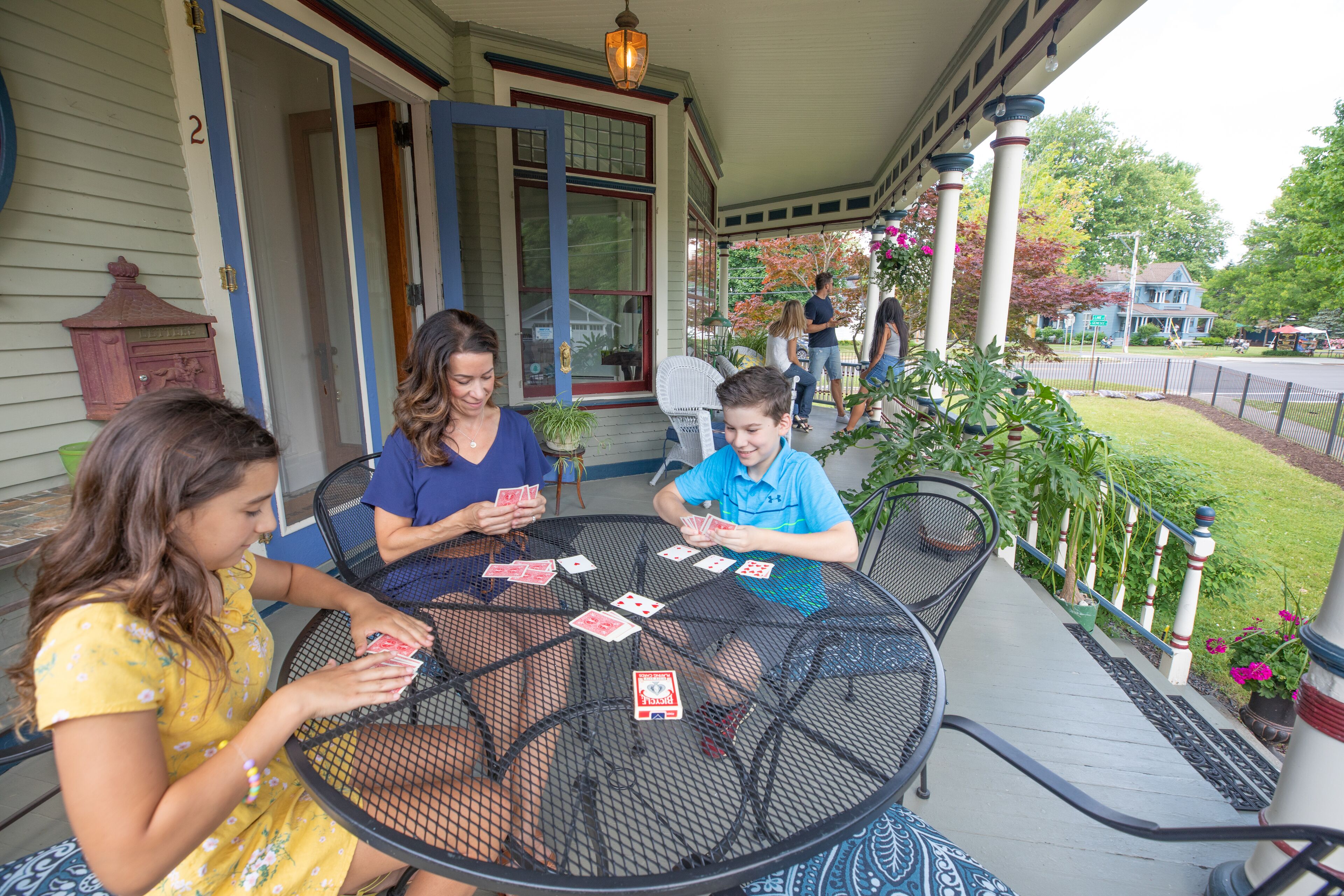 A porch with a table where people are playing cards.