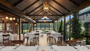 A restaurant with tables set for dining, large windows, and a wooden ceiling. - The Convent Hunter Valley Hotel (Pokolbin)