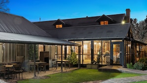A house with a covered patio, a barbecue area, and a large glass windowed room. - The Convent Hunter Valley Hotel (Pokolbin)