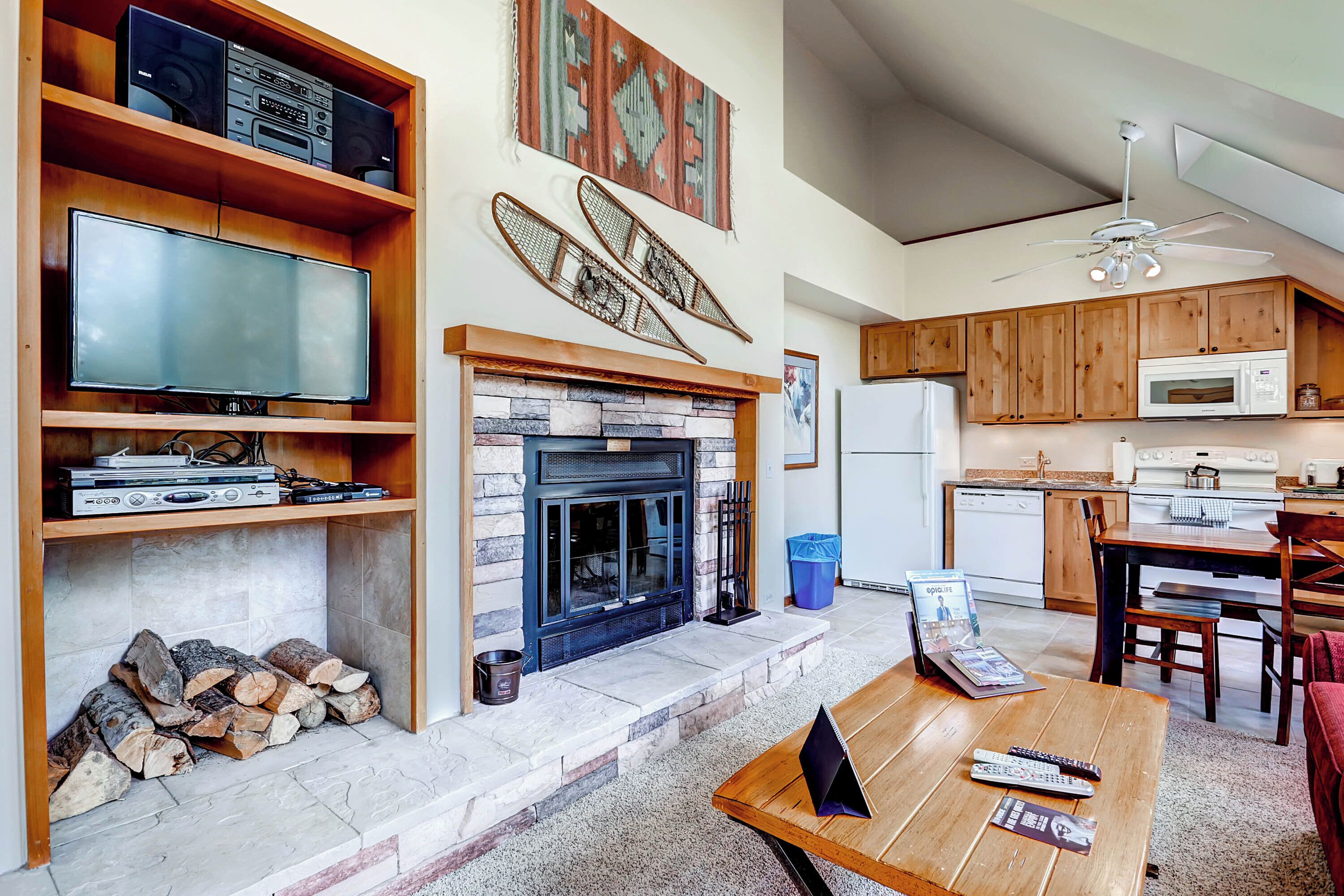 A living room with a fireplace, television, and wooden shelves.