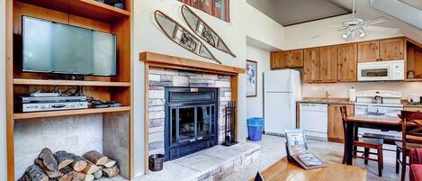 A living room with a fireplace, television, and wooden shelves.