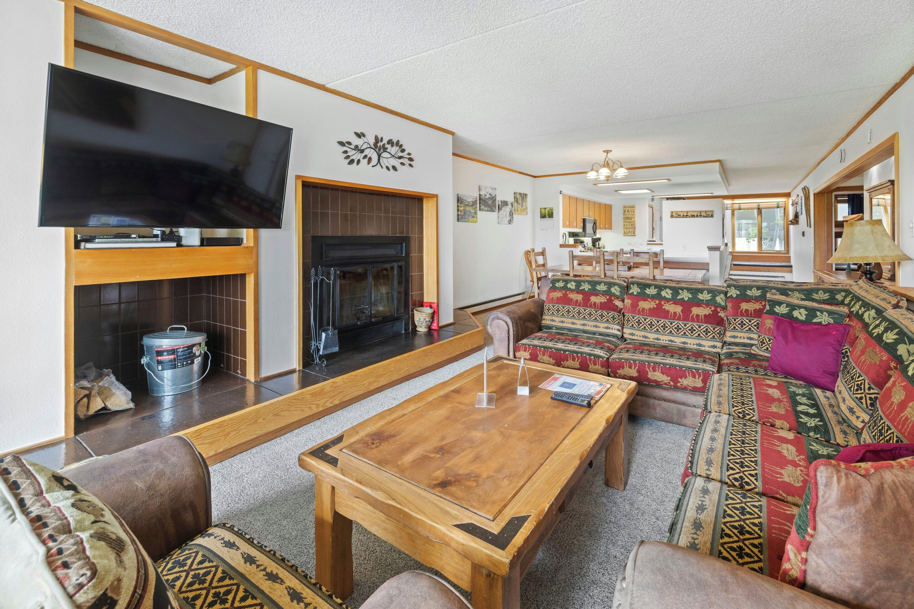 Ein Wohnzimmer mit Flachbildfernseher, Kamin, Sofa und Couchtisch.
