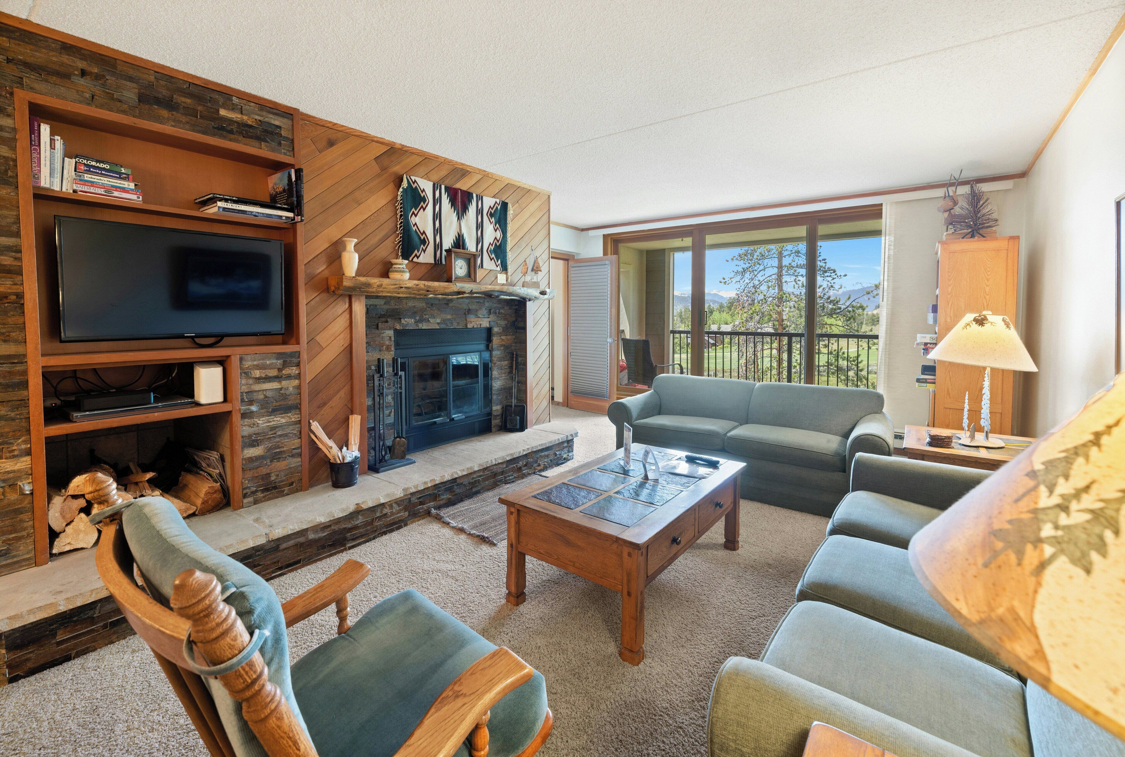 Una sala de estar con chimenea, televisor, sofá y mesa de centro.