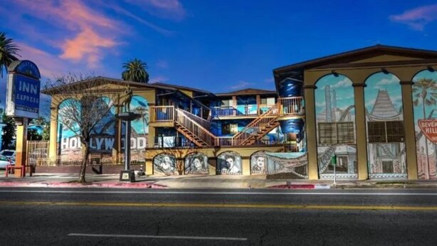 A hotel with a Hollywood-themed facade, multiple balconies, and a prominent sign for the INN Express. - Hollywood Inn Express North (Los Angeles)