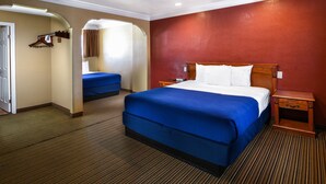 A hotel room with a large bed, a smaller bed, a wooden nightstand, a mirror, and a coat rack. - Hollywood Inn Express North (Los Angeles)