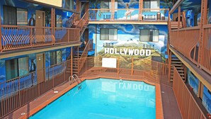 A pool area with a 'Hollywood' mural, multiple balconies, and a clear view of the pool. - Hollywood Inn Express North (Los Angeles)