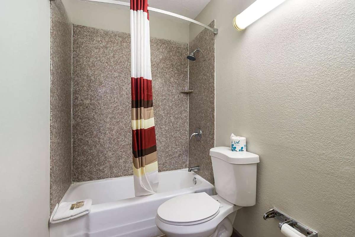 A bathroom with a bathtub, toilet, and shower.