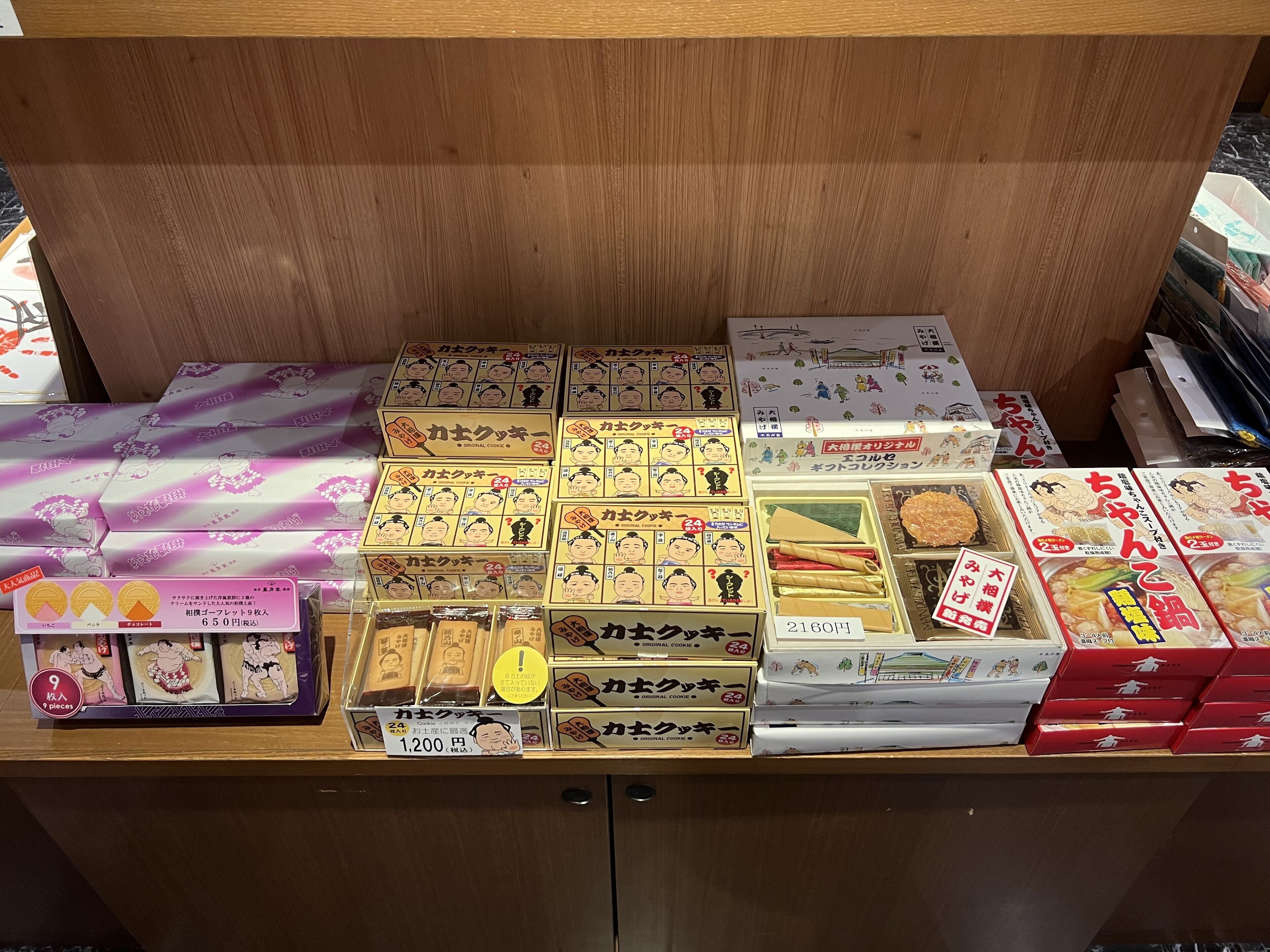 A display of various packaged goods, including boxed items and wrapped packages, with visible price tags.