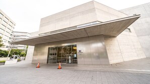 Un edificio moderno con techo plano y amplia entrada de vidrio.