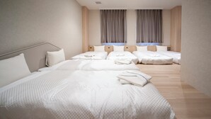 A hotel room with a large bed, two bedside tables, and a window with curtains. - Hotel IL FIORE Kasai Annex (Tokyo)