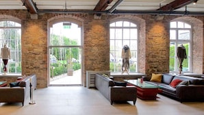 A spacious lounge with stone walls, large arched windows, and modern furniture. - Blarney Woollen Mills Hotel, BW Signature Collection (Blarney)