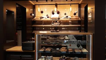 Eine Bäckerei mit einem Schild, auf dem 'THE BAKERY' steht, über einer Vitrine voller Gebäck.