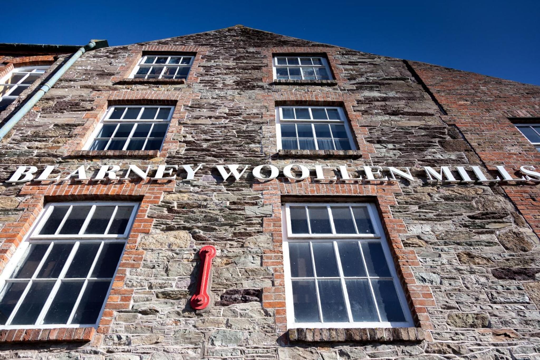 A historic building with the name "Blarney Woollen Mills" on its facade.