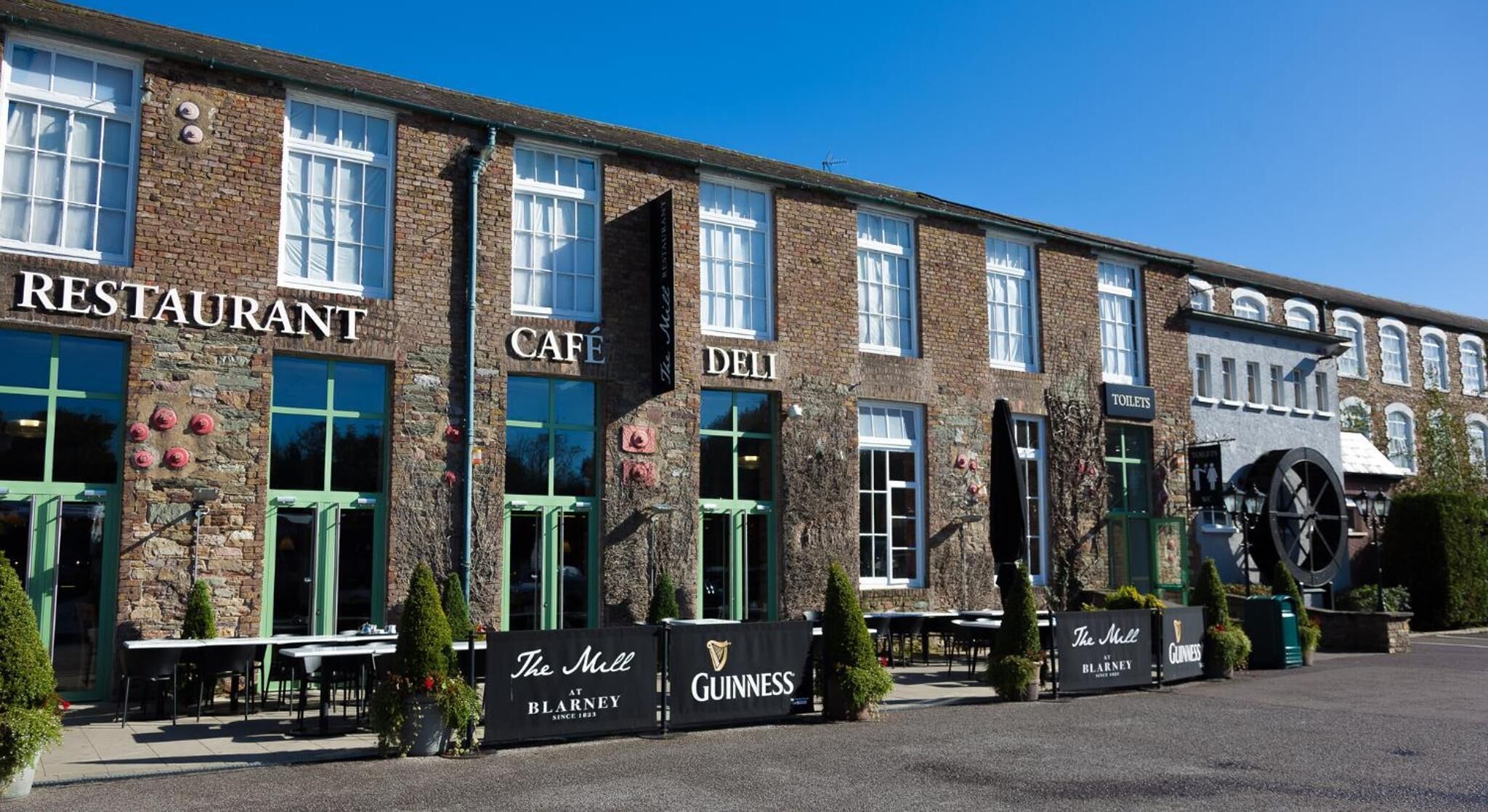 A building with multiple storefronts including a restaurant, cafe, deli, and toilets.
