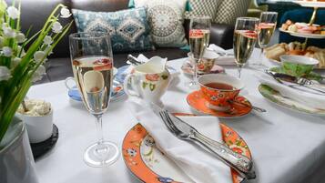 A table set for a meal with floral tableware, a vase of flowers, and a dessert dish.