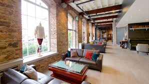 A spacious lobby with stone walls, leather sofas, and a glass coffee table. - Blarney Woollen Mills Hotel, BW Signature Collection (Blarney)