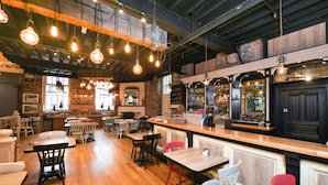 A restaurant with wooden tables and chairs, hanging light fixtures, and brick walls. - Blarney Woollen Mills Hotel, BW Signature Collection (Blarney)