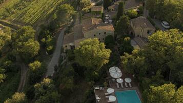 Una piscina al aire libre, sombrillas, sillones reclinables de piscina