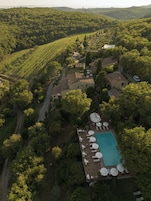 Una piscina al aire libre, sombrillas, sillones reclinables de piscina