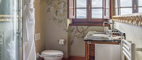 A bathroom with a wooden ceiling, a toilet, a sink, and a shower.